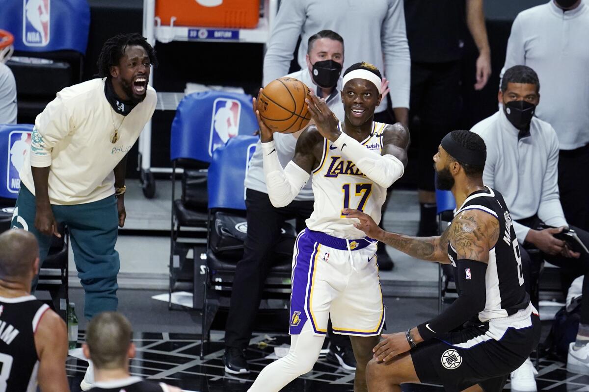Clippers guard Patrick Beverley shouts from the sideline as Lakers guard Dennis Schroder looks to shoot.