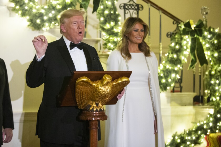 President Donald Trump with first lady Melania Trump speaks at the Grand Foyer of the White House during the Congressional Ball, Thursday, Dec. 12, 2019, in Washington.