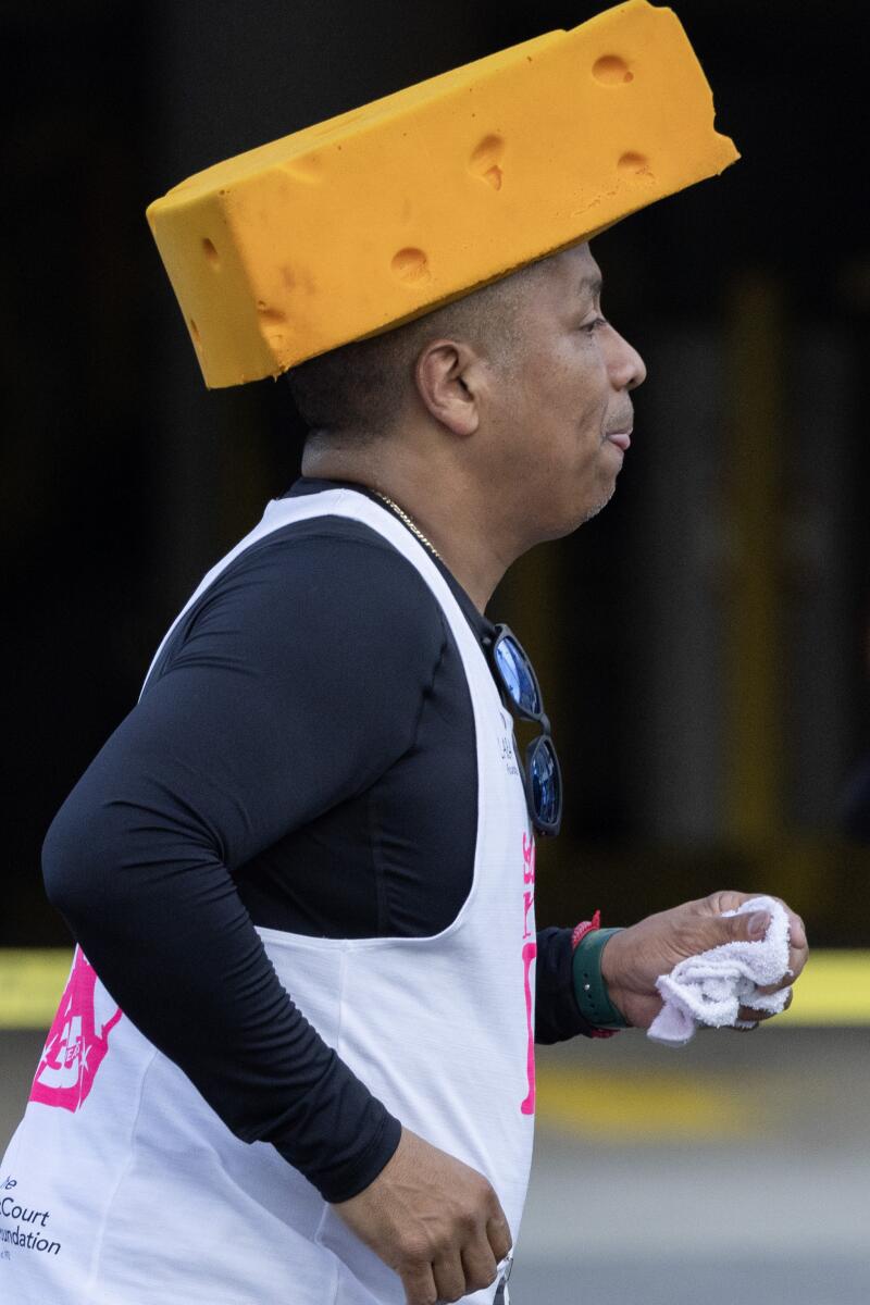 一名跑步者在洛杉矶马拉松比赛中戴着一顶奶酪头帽子。
