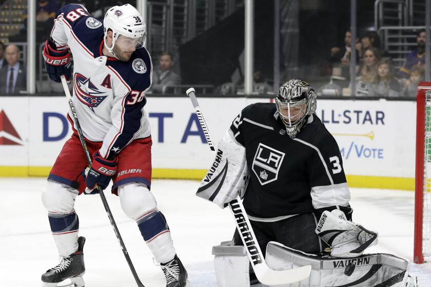Los Angeles Kings goaltender Jonathan Quick, right, stops a shot next to Columbus Blue Jackets' Boone Jenner during the first period of an NHL hockey game Monday, Jan. 6, 2020, in Los Angeles. (AP Photo/Marcio Jose Sanchez)