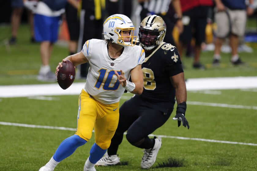 Los Angeles Chargers quarterback Justin Herbert (10) scrambles under pressure fromNew Orleans Saints defensive tackle Sheldon Rankins (98) in the second half of an NFL football game in New Orleans, Monday, Oct. 12, 2020. (AP Photo/Brett Duke)