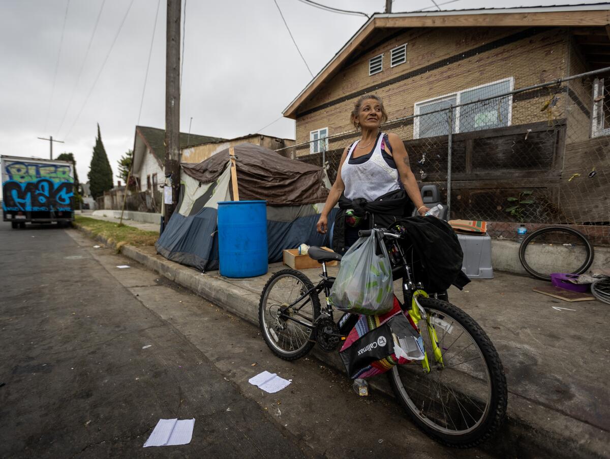 A woman next to a bicycle on a South Los Angeles street. 