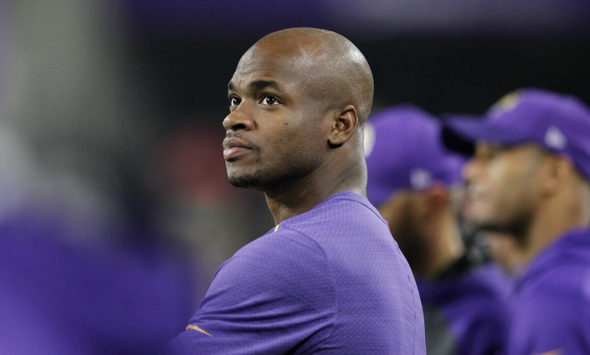 Injured Minnesota Vikings running back Adrian Peterson stands on the sideline during a game against Dallas on Dec. 1.