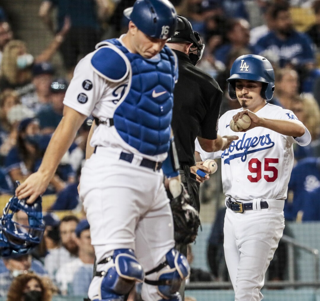 Dodgers bat boy Branden Vandal delivers balls to the umpire during a game against the Atlanta Braves.
