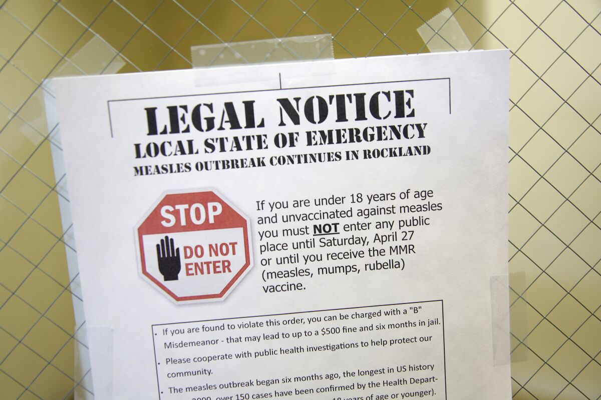 FILE - In this Wednesday, March 27, 2019 file photo, a sign at the Rockland County Health Department in Pomona, N.Y., explains the local state of emergency regarding a measles outbreak. There were nearly 1,300 case of measles in the U.S. through November 2019 - the largest number in 27 years. There were no deaths but about 120 people ended up in the hospital. (AP Photo/Seth Wenig)