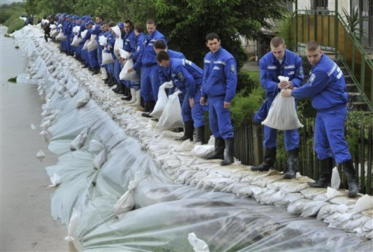 Police academy students load sandbags onto a broken dike to protect homes from flooding water in the village of Ocsanalos, northeastern Hungary, Tuesday, May 18, 2010. Several swollen rivers causing floods throughout Hungary, while roads remain closed due to the unusual wet weather and heavy rains. Heavy rains that began in central Europe last weekend also are causing flooding in areas of Poland , Slovakia and the Czech Republic, with rivers bursting their banks and inundating low-lying homes and roads, and cutting off villages. (AP Photo/Bela Szandelszky)