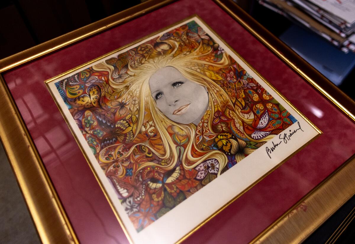 A colorful signed and framed copy of Barbra Streisand's 1974 album, "Butterfly," in a gold frame.