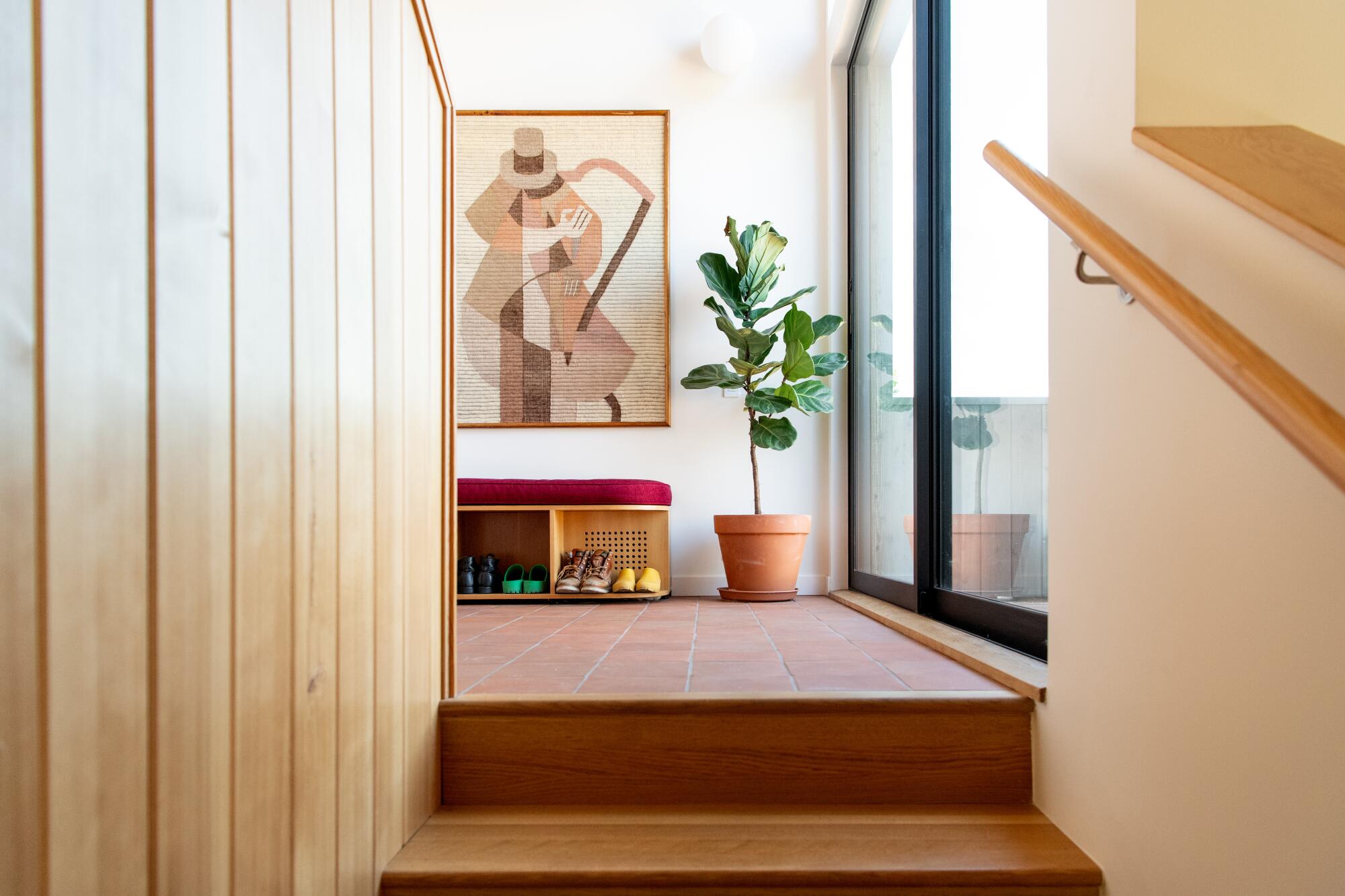 A wooden bench and plants at the top of the stairs