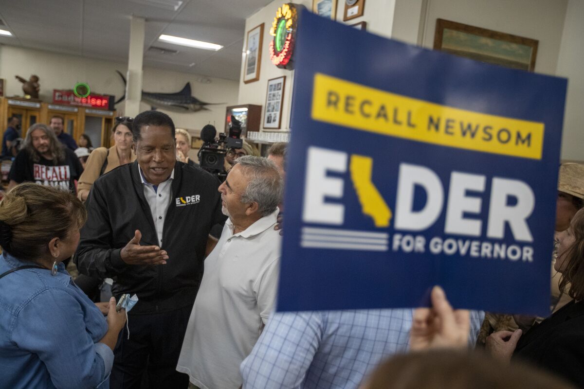 Recall candidate Larry Elder, second from left, chats with supporters during a stop at Philippe The Original deli on Monday.