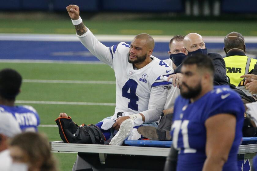 Dallas Cowboys quarterback Dak Prescott (4) lifts his fist to cheers from fans as he is carted off the field.