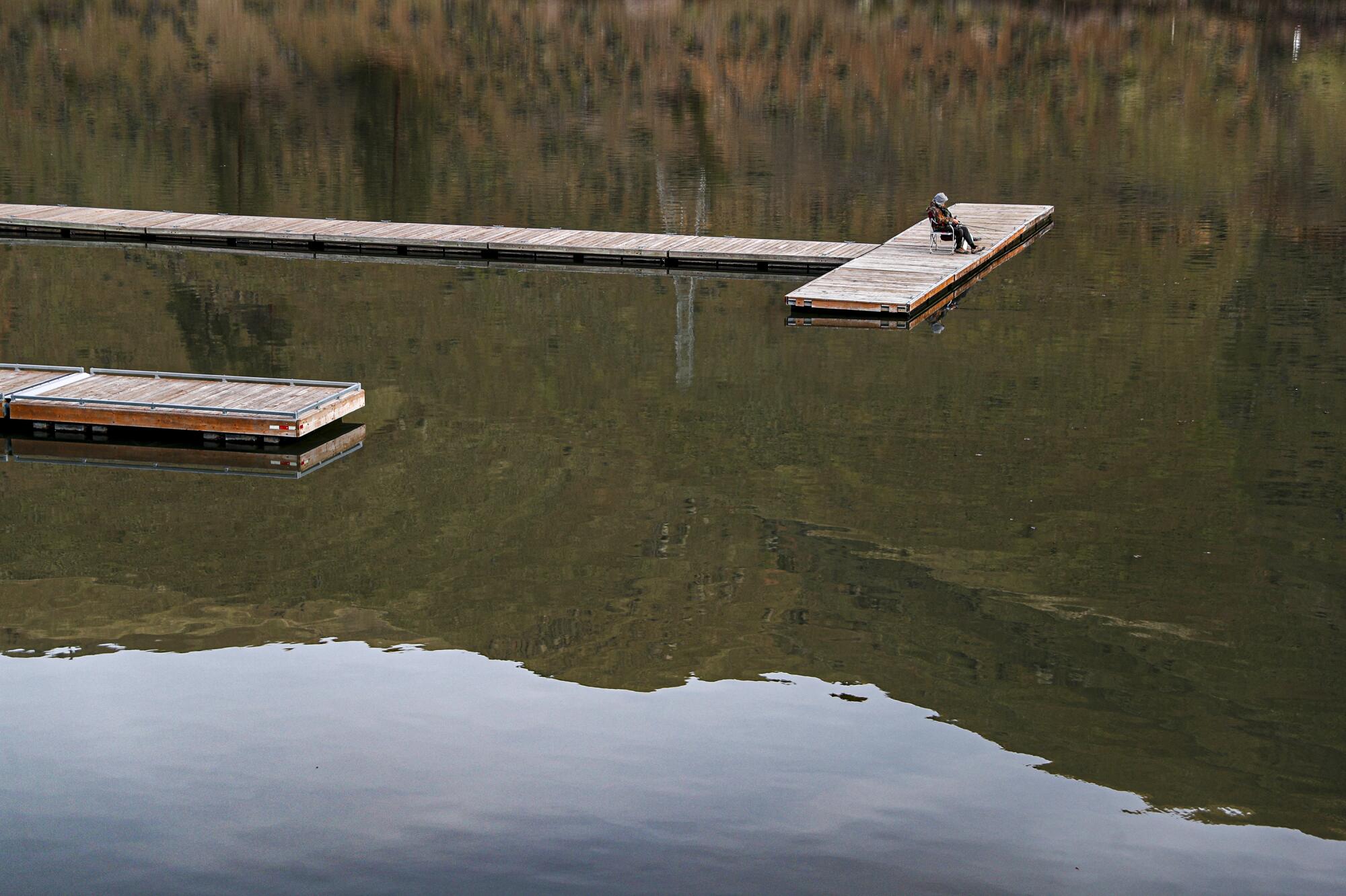 A person fishes from a dock on the Snake River.