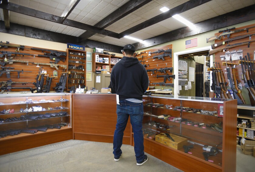 A customer fills out the necessary paperwork to purchase a rifle at AO Sword Firearms in El Cajon on March 19, 2020.