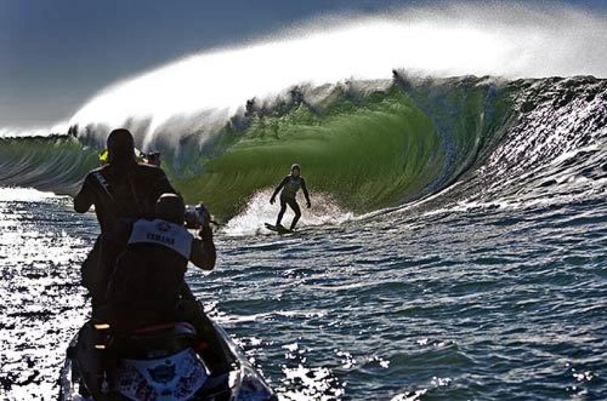 T.J. Gumiela, 18, of Long Beach, N.Y., is close to being swallowed by a large tube created by a slab wave in the Pacific Northwest as videographers capture the action.