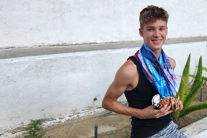 JJ Harel, a freshman high jumper at Chaminade, shows off his 27 medals earned this past year in track and field competitions.