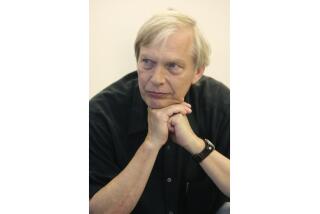 Journalist Bob Edwards in a black t-shirt leaning his chin on his hands