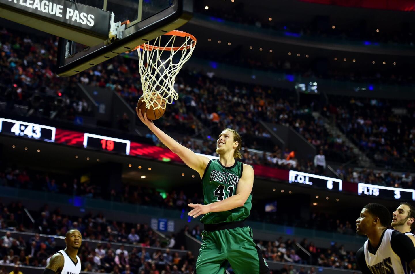 Boston Celtics' Kelly Olynyk (C) scores against the Sacramento Kings during a basketball match of the NBA Global Games at the Mexico City Arena, on December 03, 2015, in Mexico City.