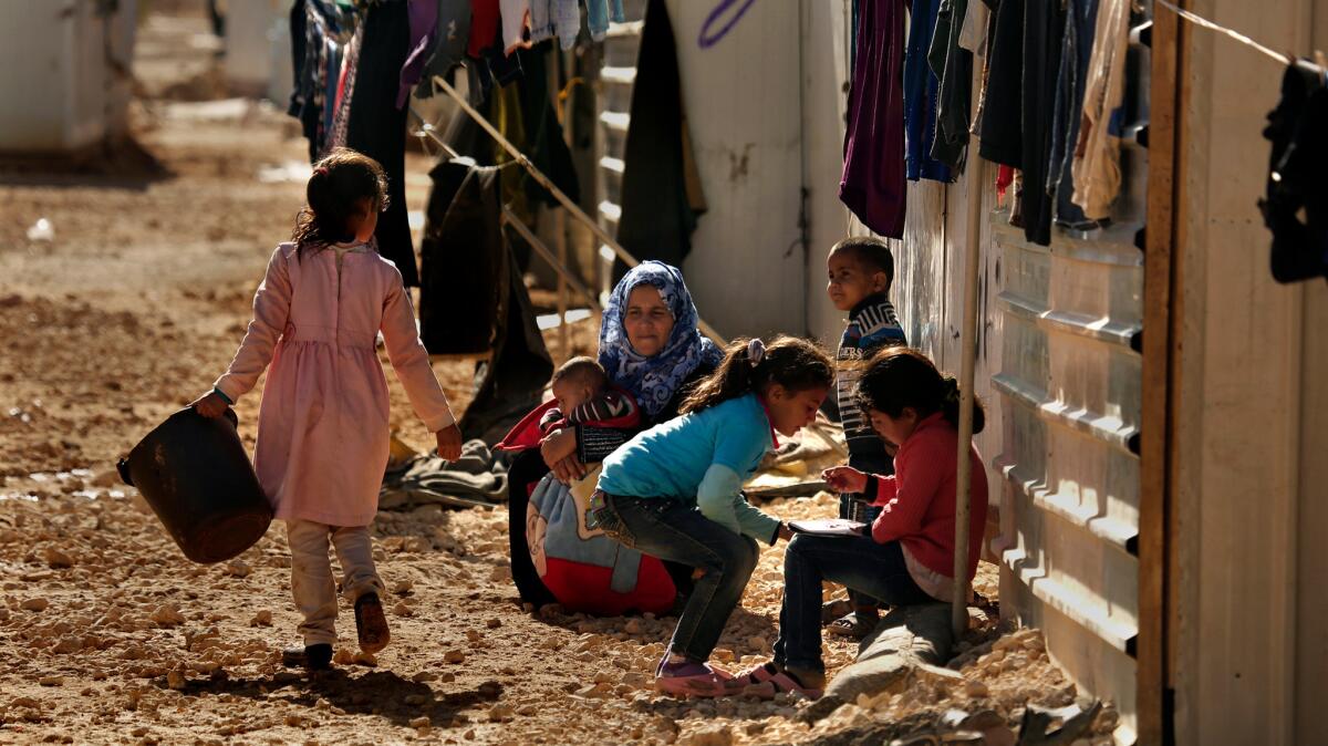 A woman sits with children at Jordan's Zaatari refugee camp, home to more than 85,000 refugees.