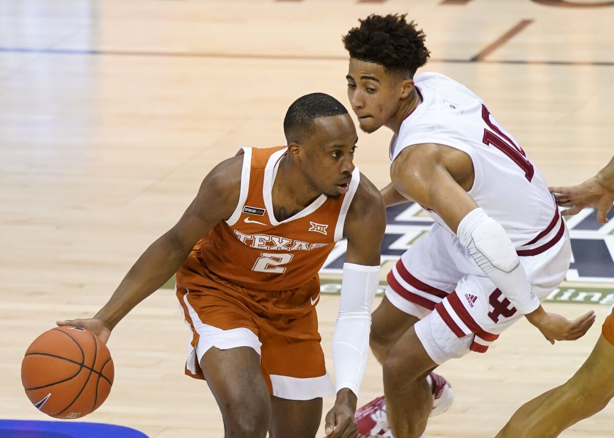 Texas guard Matt Coleman III (2) drives around Indiana guard Rob Phinisee (10) in the first half of a semifinal NCAA college basketball game in the Maui Invitational tournament, Tuesday, Dec. 1, 2020, in Asheville, N.C. (AP Photo/Kathy Kmonicek)