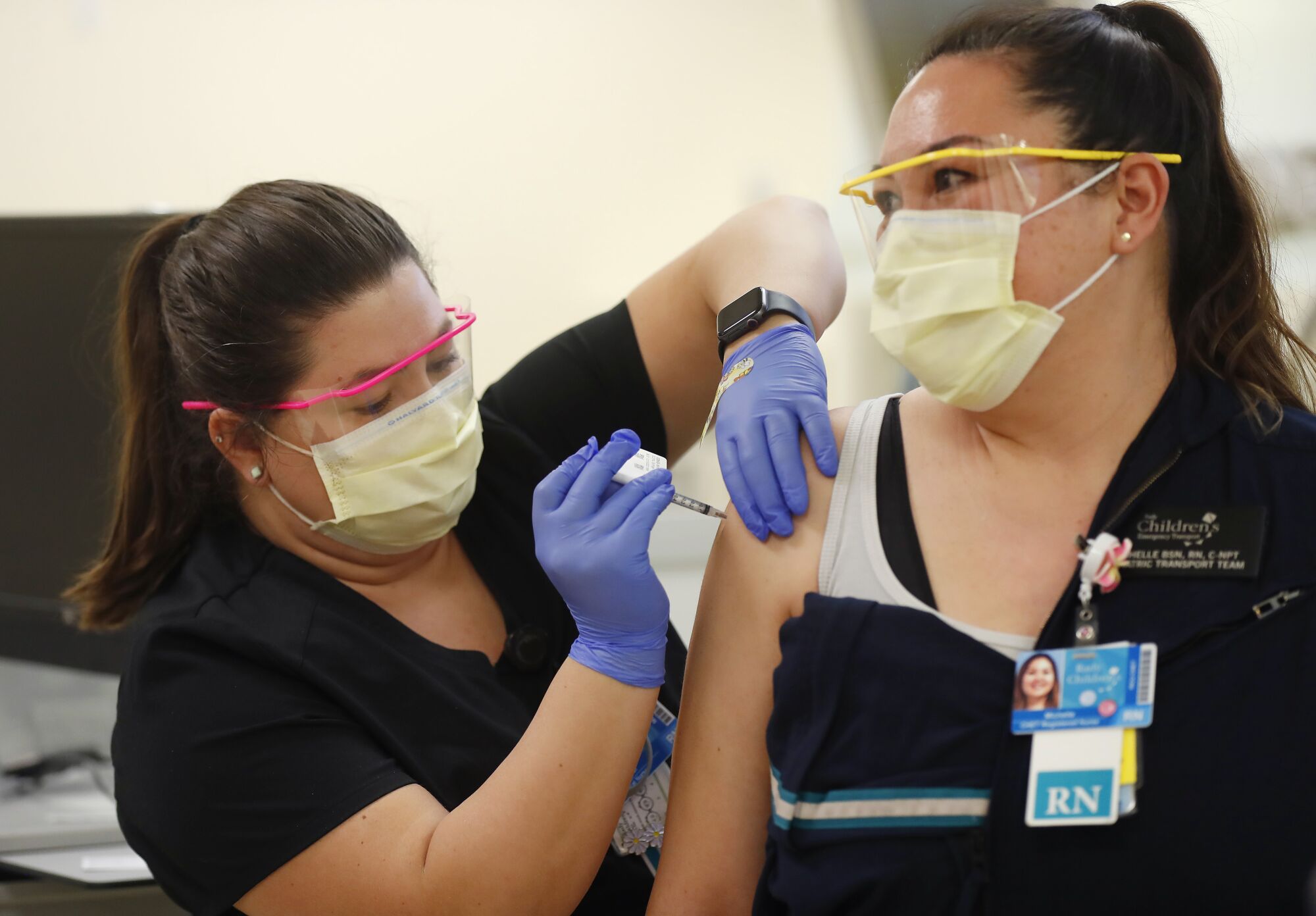 RN Rachel Marrs gives a Pfizer-BioNTech COVID-19 Vaccine shot to RN Michelle Gaano at Rady Children's Hospital.