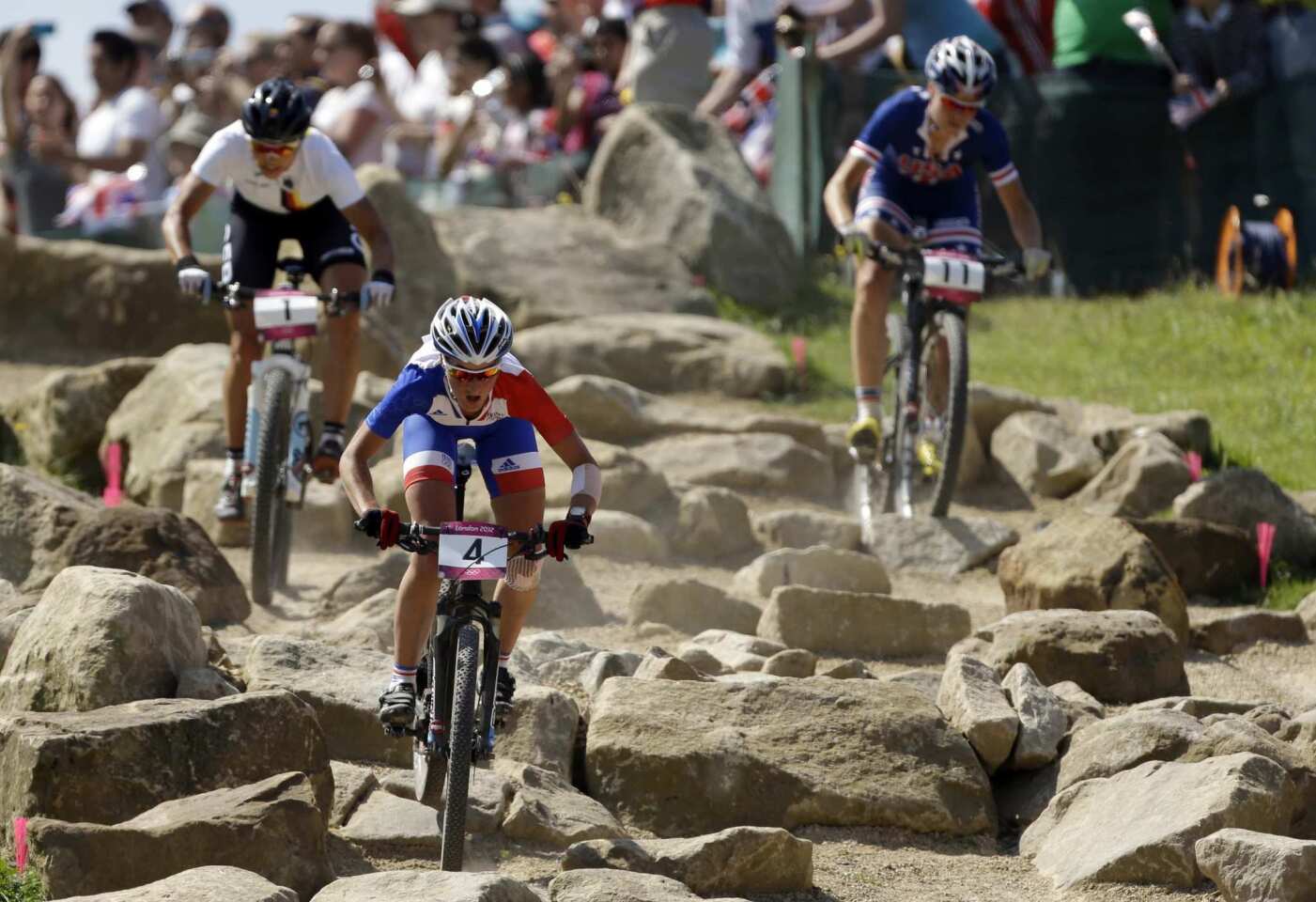 Gold medal's winner Julie Bresset, of France, leads Germany's silver medalist Sabine Spitz, left, and United States' bronze medalist Georgia Gould during the women's cross-country mountain bike race.