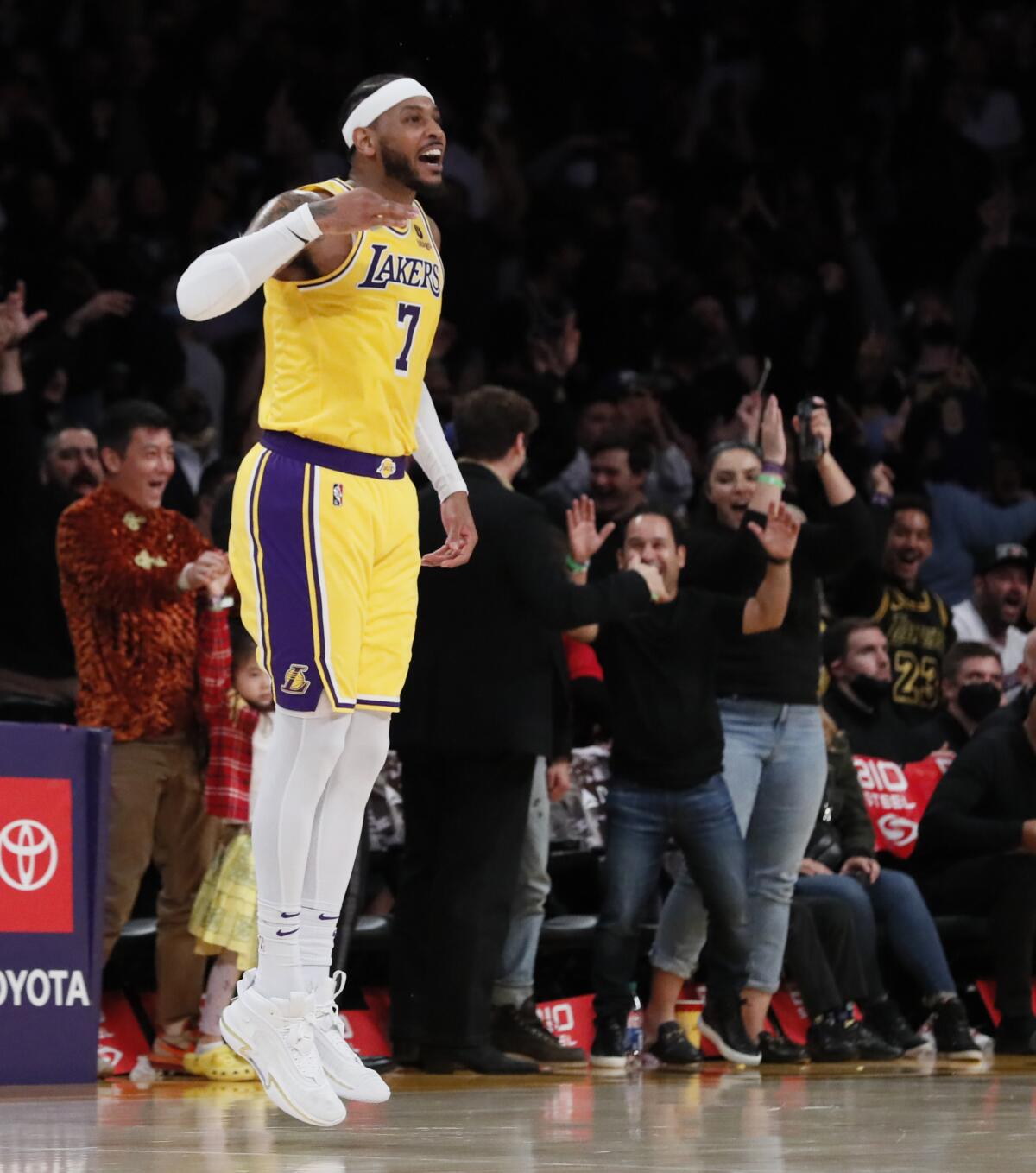 The Lakers' Carmelo Anthony smiles and jumps during a game.