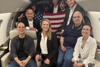 Evan Gershkovich, left, Alsu Kurmasheva, right, and Paul Whelan, second from right, and others aboard a plane, 