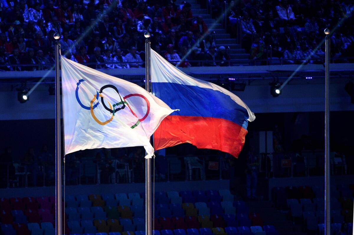 Flags of the Olympic Games and Russia displayed side by side during the closing ceremony of the Winter Olympics in Sochi, Russia, on Feb. 23, 2014.
