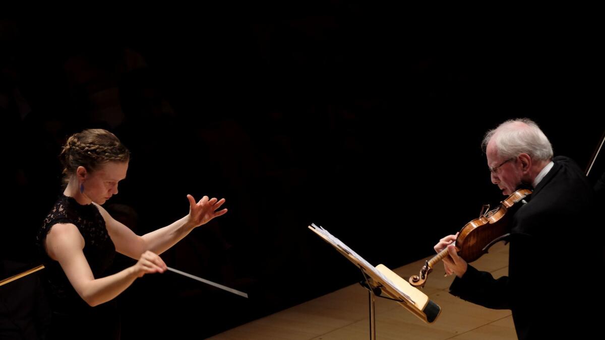 Mirga Grazinyte-Tyla, left, conducts the Los Angeles Philharmonic and soloist Gidon Kremer in Weinberg's Violin Concerto at Walt Disney Concert Hall Thursday night.