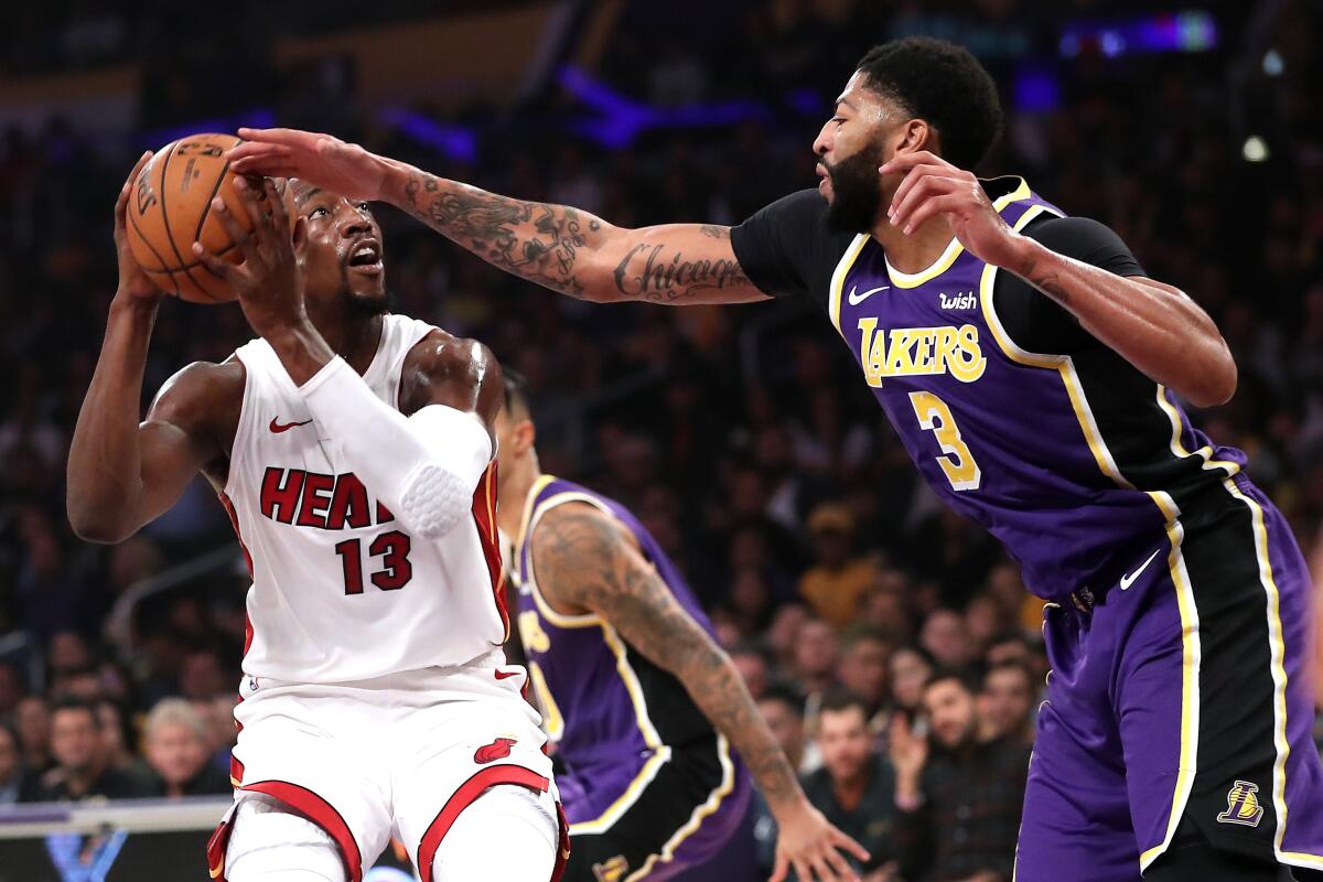 Lakers forward Anthony Davis, right, tries to block a shot by Miami Heat forward Bam Adebayo during the Lakers' 95-80 victory Friday at Staples Center.