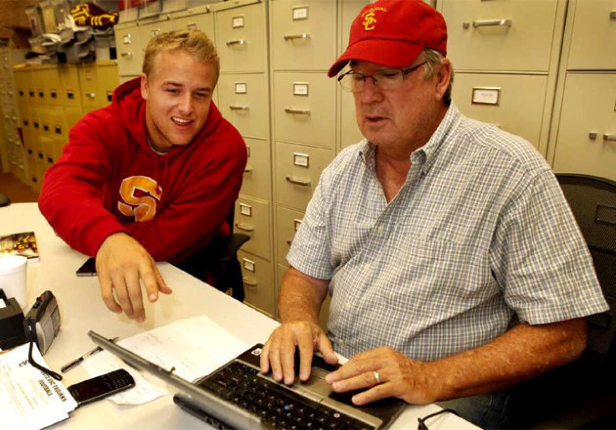 USC football quarterback Matt Barkley, left, teaches Los Angeles Times sports columnist T. J. Simers, how to set up and use a twitter account in August.