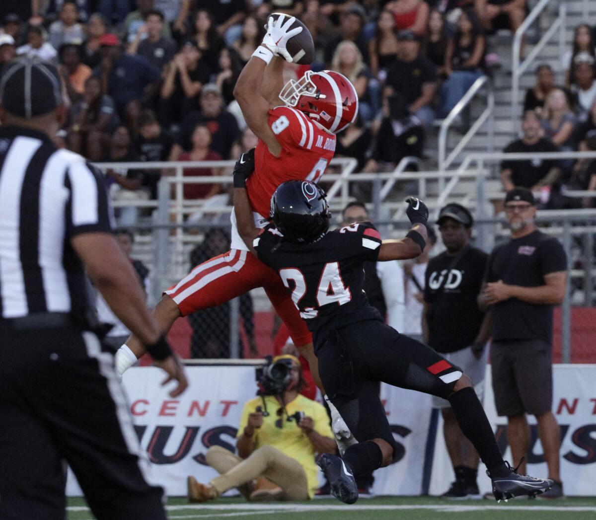 Mater Dei wide receiver Marcus Brown leaps above Corona Centennial defender Charles Castille for the game's first touchdown.