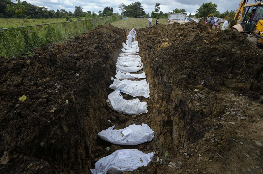 Un equipo forense entierra a un grupo de migrantes que murieron tratando de cruzar la brecha del Darién