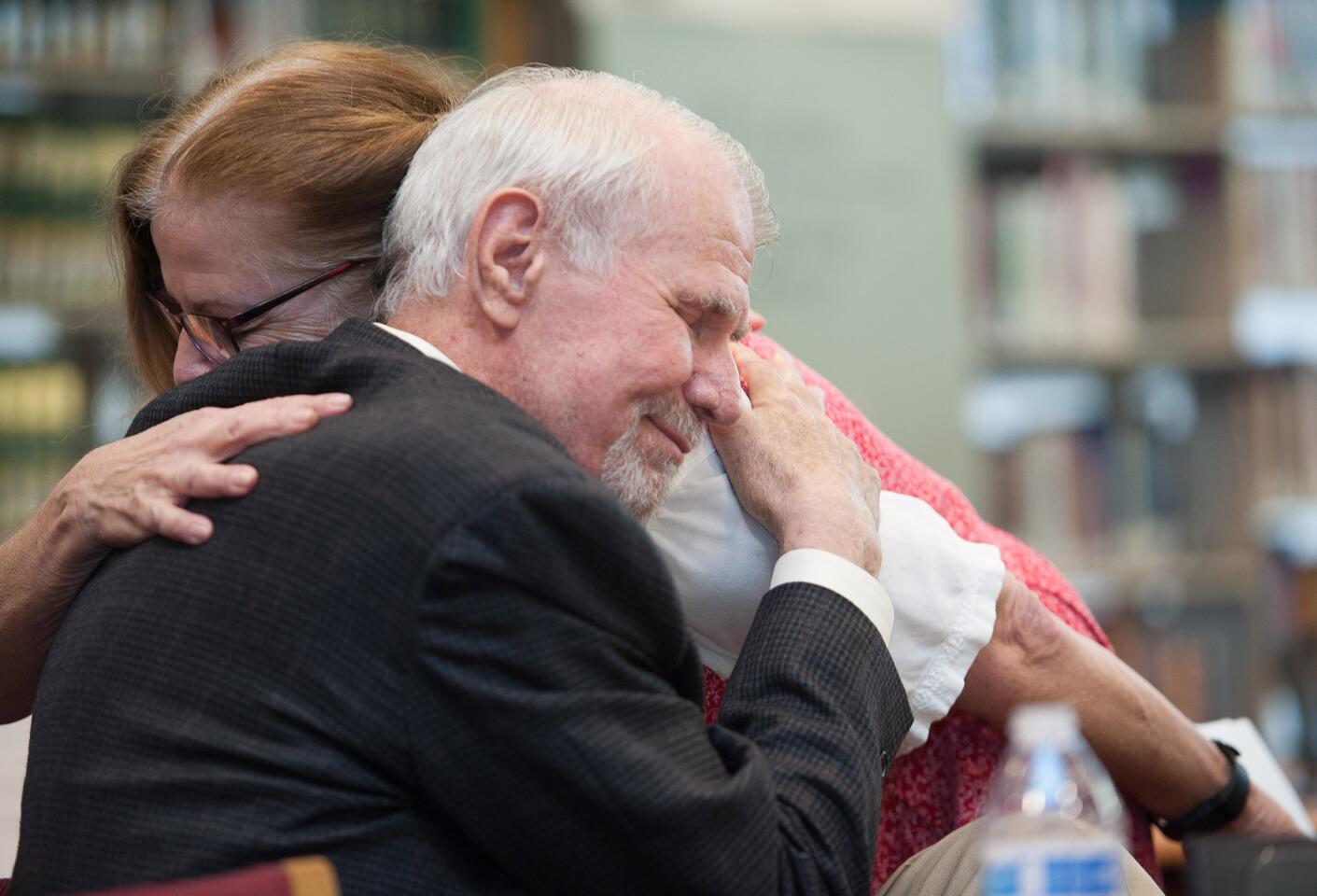 Former Burroughs High English teacher Steve Campbell gets a hug from English teacher Jill Sullivan after she spoke about Campbell's influence on her during Saturday's dedication of the school library in Campbell's name.