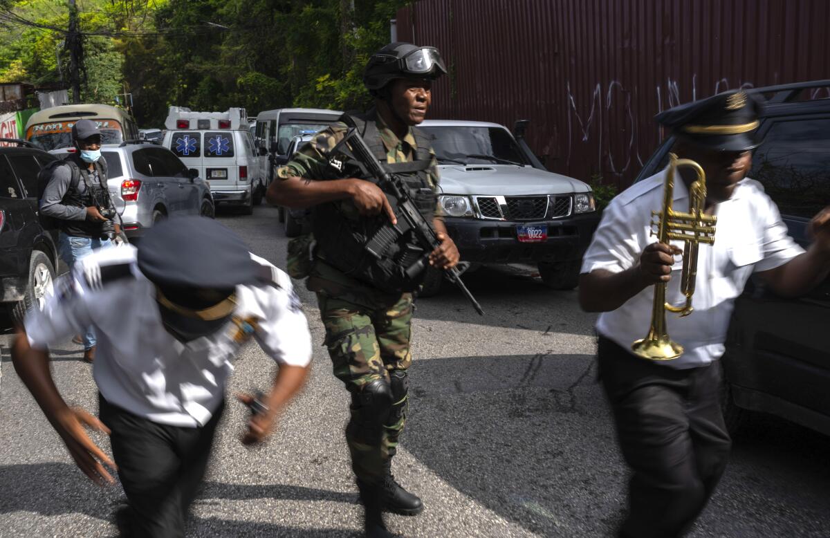 Police escort musicians arriving for the swearing-in ceremony of a transitional council tasked with selecting a new prime minister and cabinet at the Prime Minister's office in Port-au-Prince, Haiti, Thursday, April 25, 2024. (AP Photo/Ramon Espinosa)