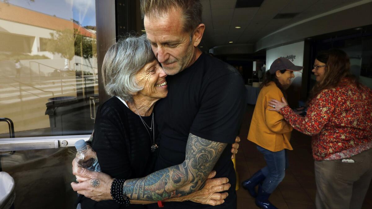 Jody Gabbard hugs his mother, Kay Gabbard, at the Malibu Strong community Thanksgiving, where they also volunteered. They lost their Malibu home of 45 years.