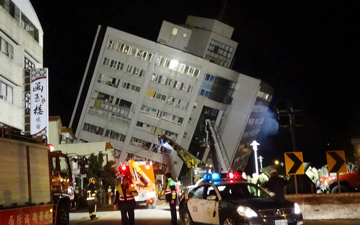 Rescuers are seen entering a building that collapsed onto its side from a 6.4 magnitude earthquake in Hualien County, eastern Taiwan, on Feb. 7, 2018.