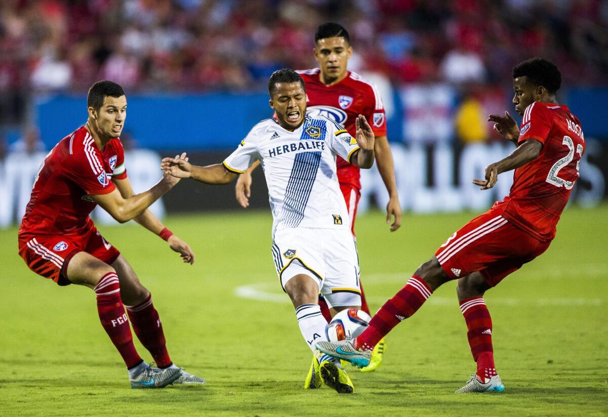 Galaxy's Giovani Dos Santos loses the ball to FC Dallas' Kellyn Acosta near Matt Hedges, left, and Victor Ulloa on Aug. 15.