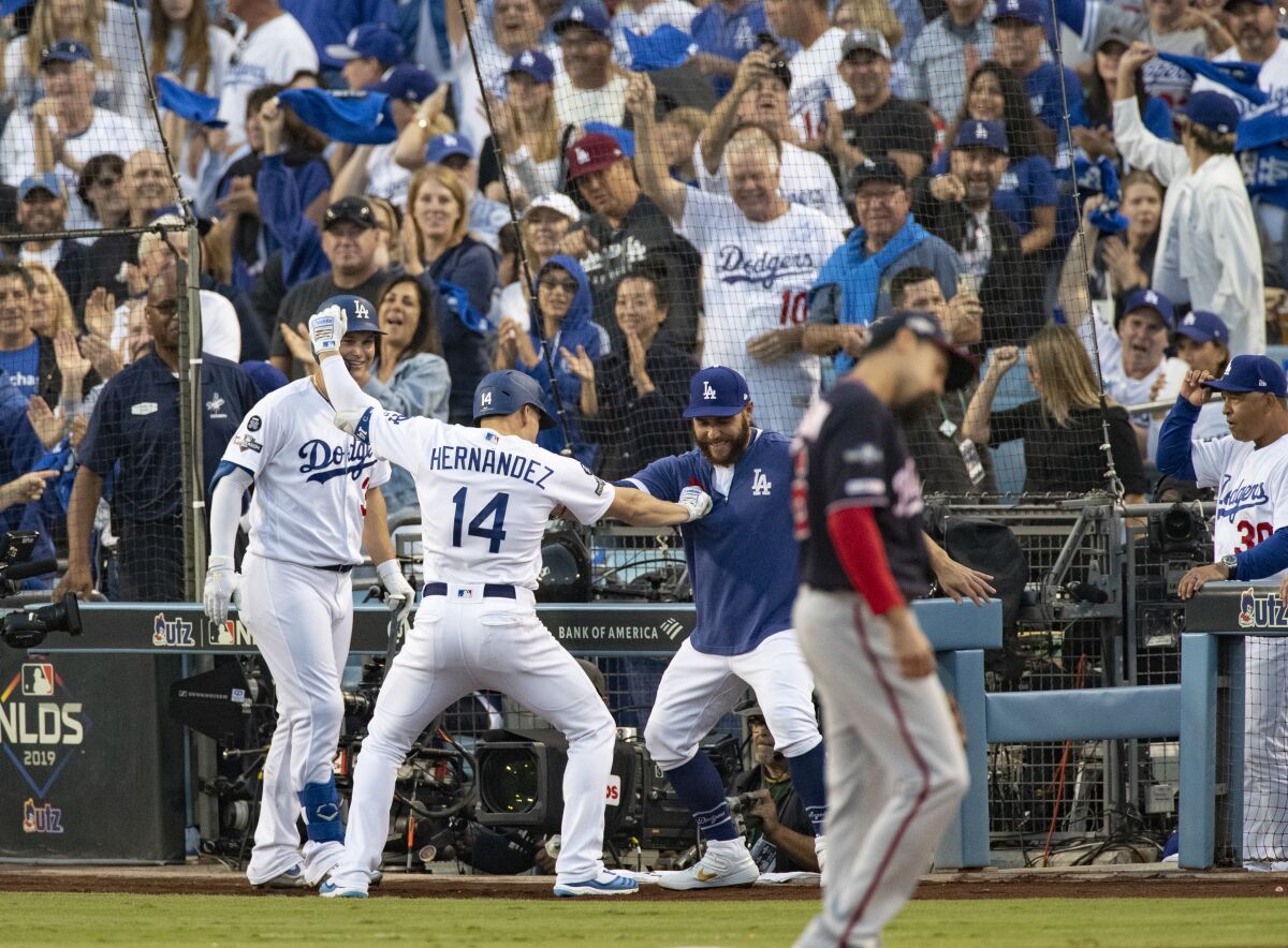 Dodgers left fielder Enrique Hernandez (14) celebrates his solo homer with Joc Pederson (31) and Russell Martin in the second inning of Game 5 of the NLDS at Dodger Stadium on Wednesday.