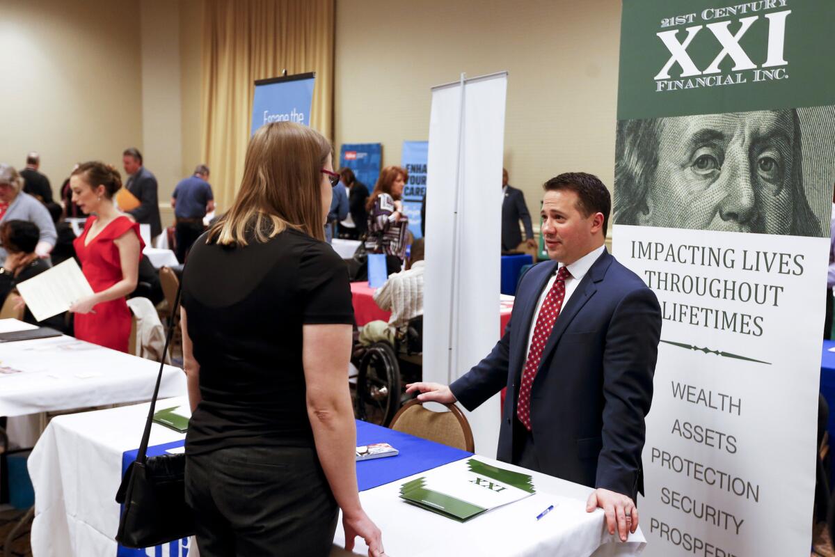 Recruiters speak to attendees at a job fair in Pittsburgh on March 30.