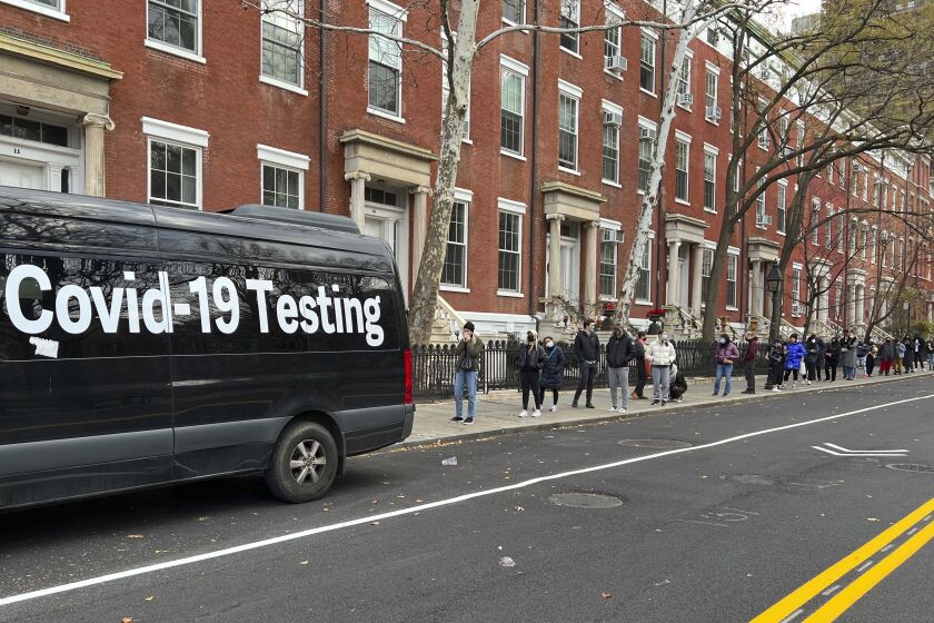 A line stretches down the block as people wait to be tested for COVID-19 in New York on Thursday.