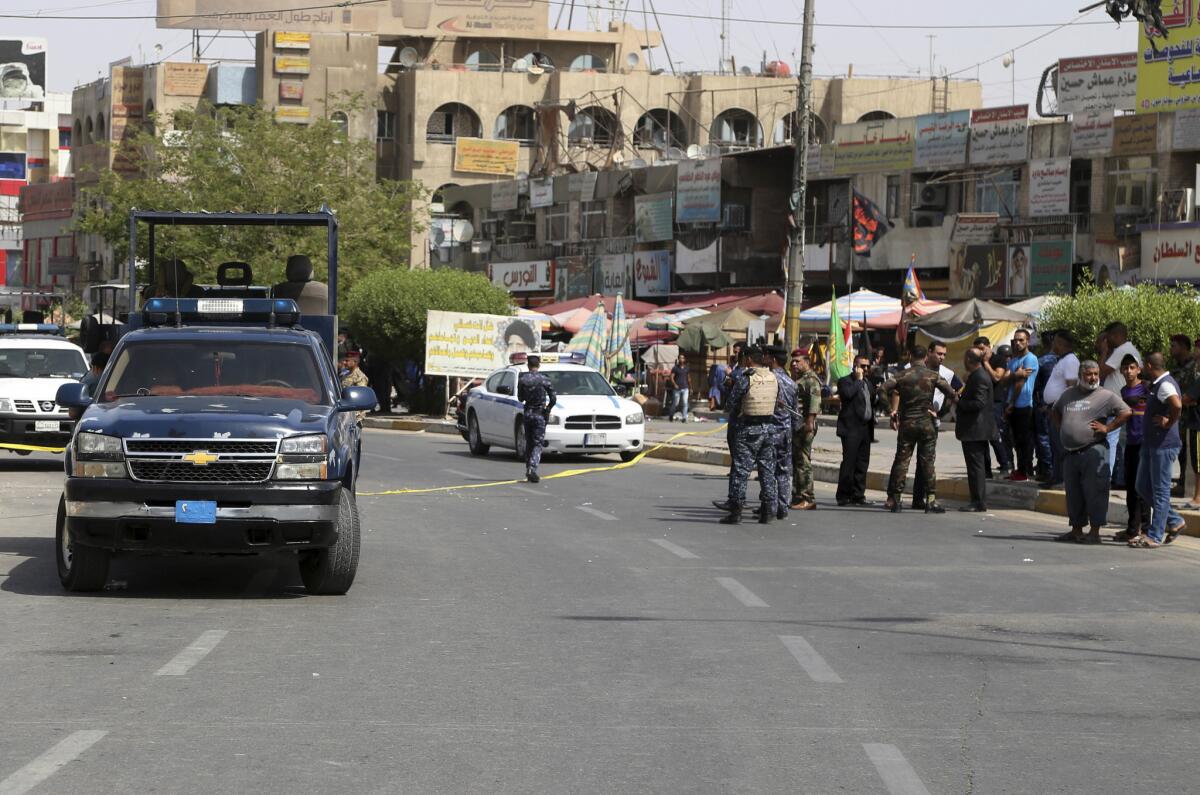 Iraqi security forces close the scene of a suicide bomb attack at a gathering of construction workers Tuesday in the eastern New Baghdad neighborhood of the capital.