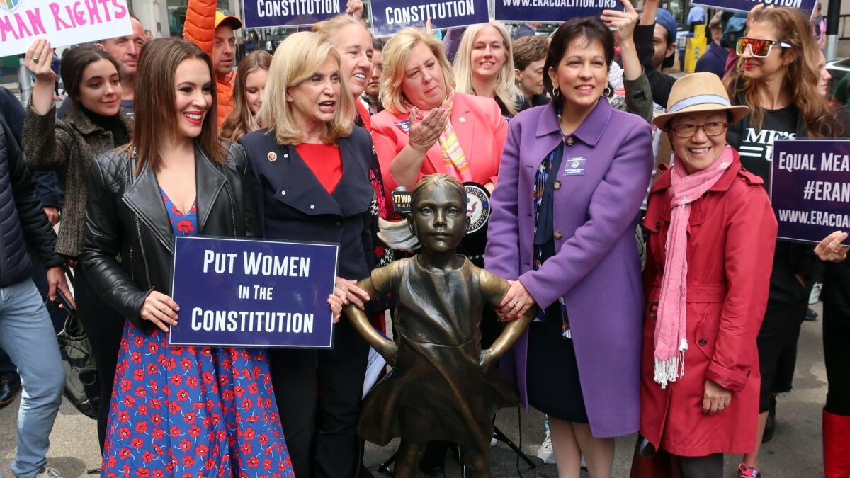 Pro-ERA activists including actress Alyssa Milano rally for the passage of the Equal Rights Amendment behind the "Fearless Girl" statue in New York on June 4.