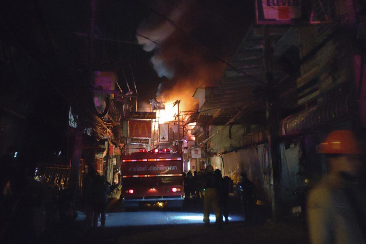 In this Sunday, Sept. 12, 2021, photo, firefighters work the scene of a structure fire at the Nashaa Club, Pattaya, Chonburi province, Thailand. The fire in the famous Thai resort city of Pattaya has badly damaged the large nightclub catering to Indian tourists. A city official said there were no deaths or injuries from the Sunday night blaze at the club on the city's well-known Walking Street. (AP Photo/Narong Sattayakun)