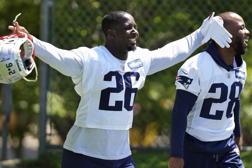 New England Patriots running back Sony Michel raises his arms while stepping on the field with James White