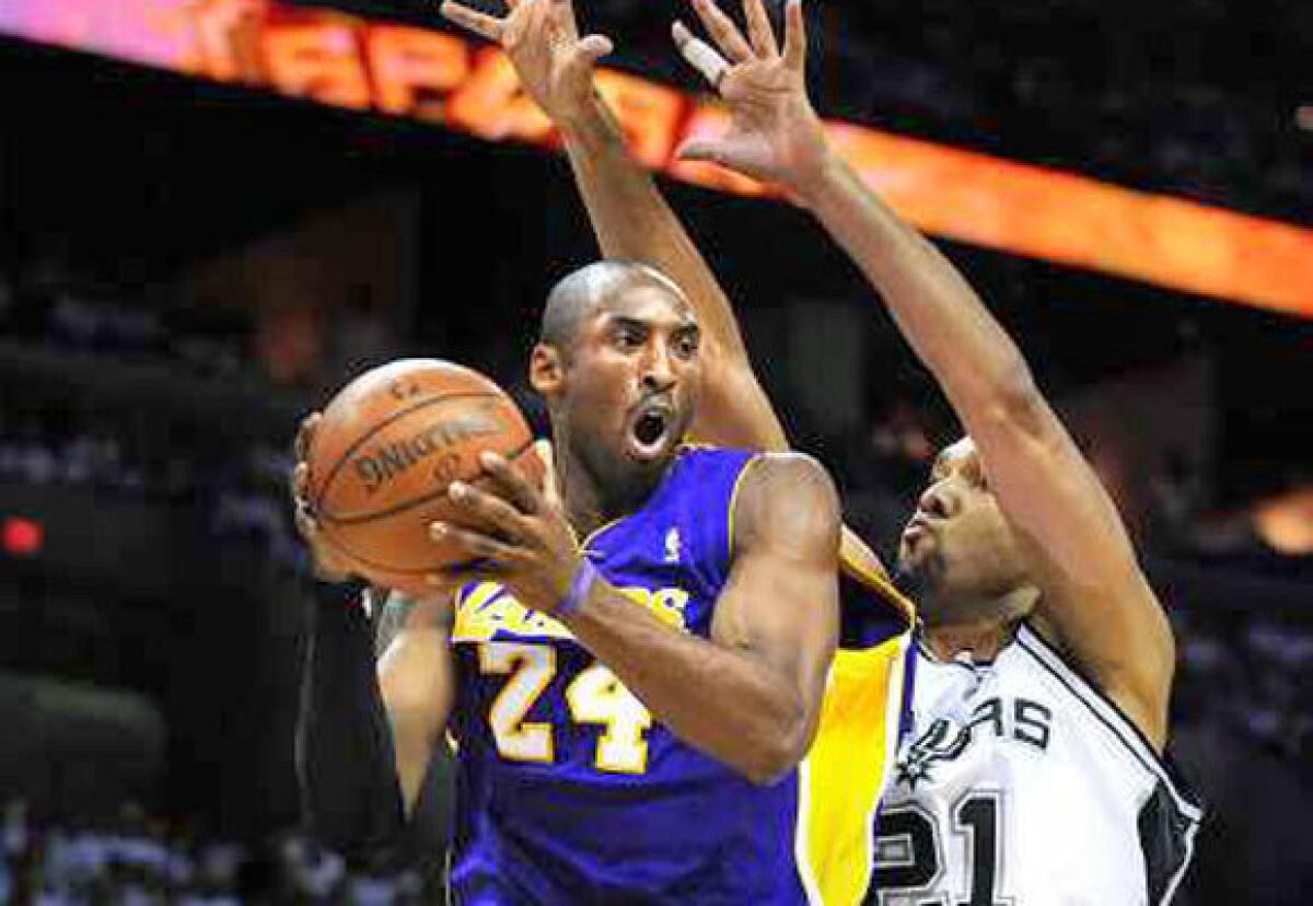 Kobe Bryant looks to pass while being defended by Tim Duncan during a 2008 Lakers-Spurs game.