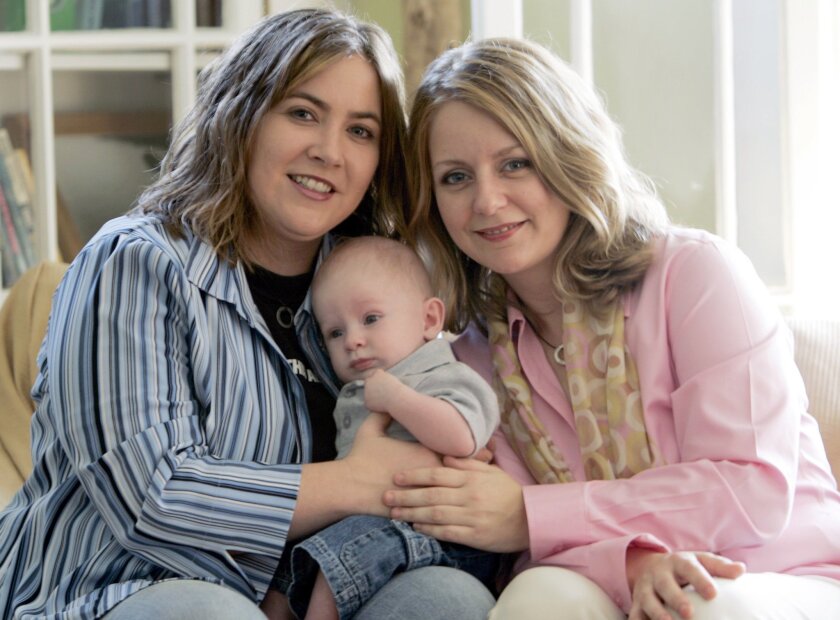 Cari Searcy, left, and Kim McKeand pose in 2006 for a portrait with son Khaya in Mobile, Ala.