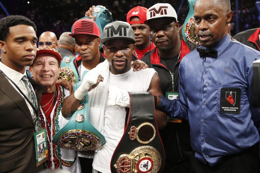 Floyd Mayweather Jr., center, stands with referee Kenny Bayless, right, after defeating Andre Berto for the WBC/WBA welterweight titles.