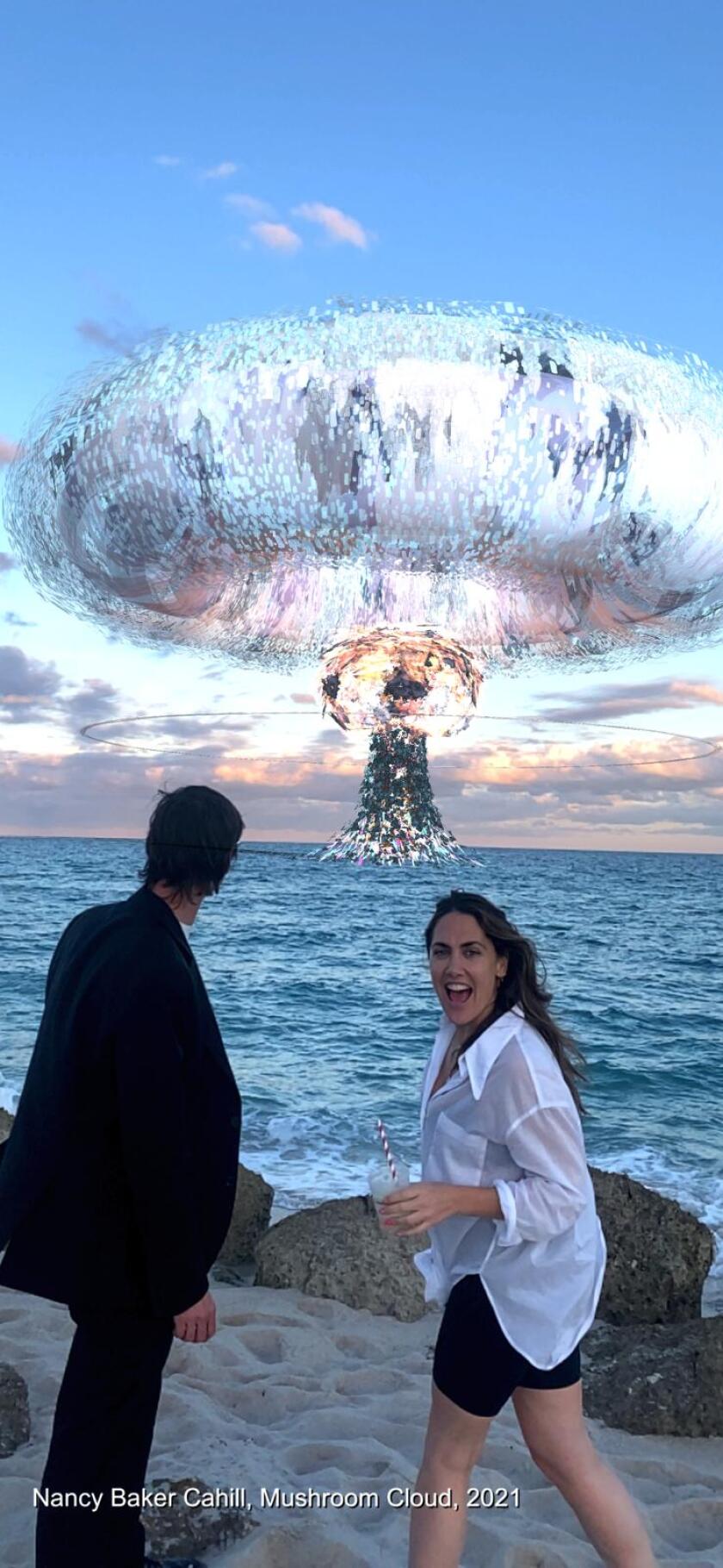 Two people stand in front of Nancy Baker Cahill's "Mushroom Cloud" on the beach in Miami.