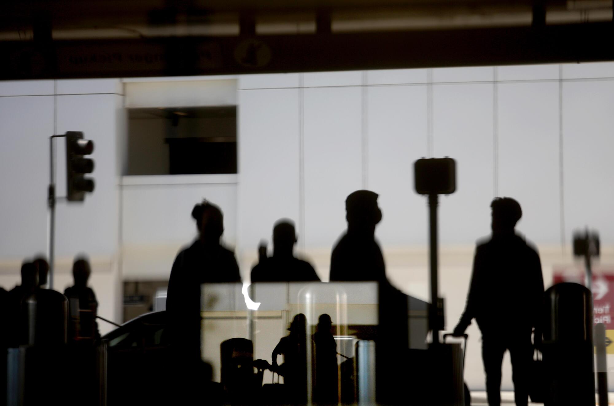 Travelers are seen in silhouette.