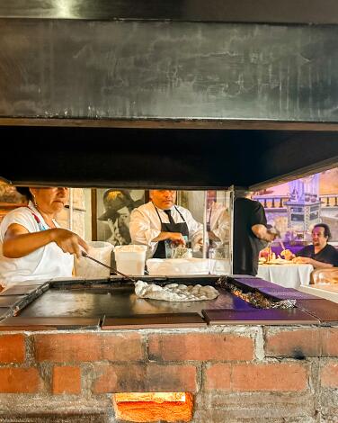 Tortillas being made on a large flat grill